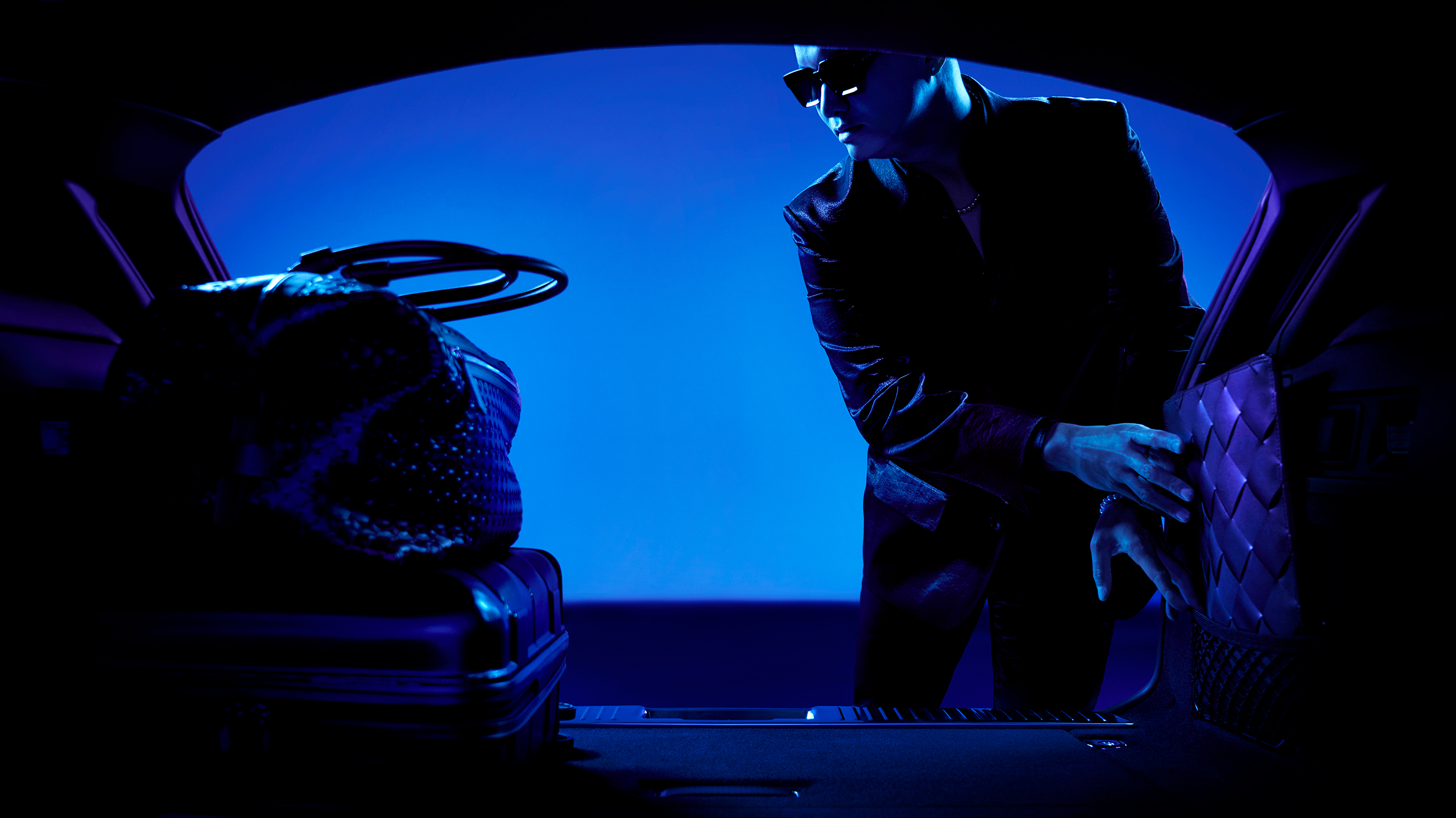 Man loading luggage in the Jaguar XF